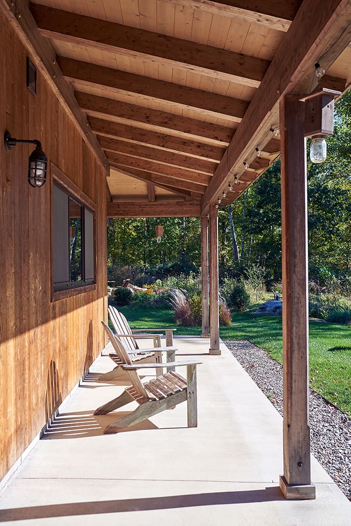 A covered porch with an Adirondack chair