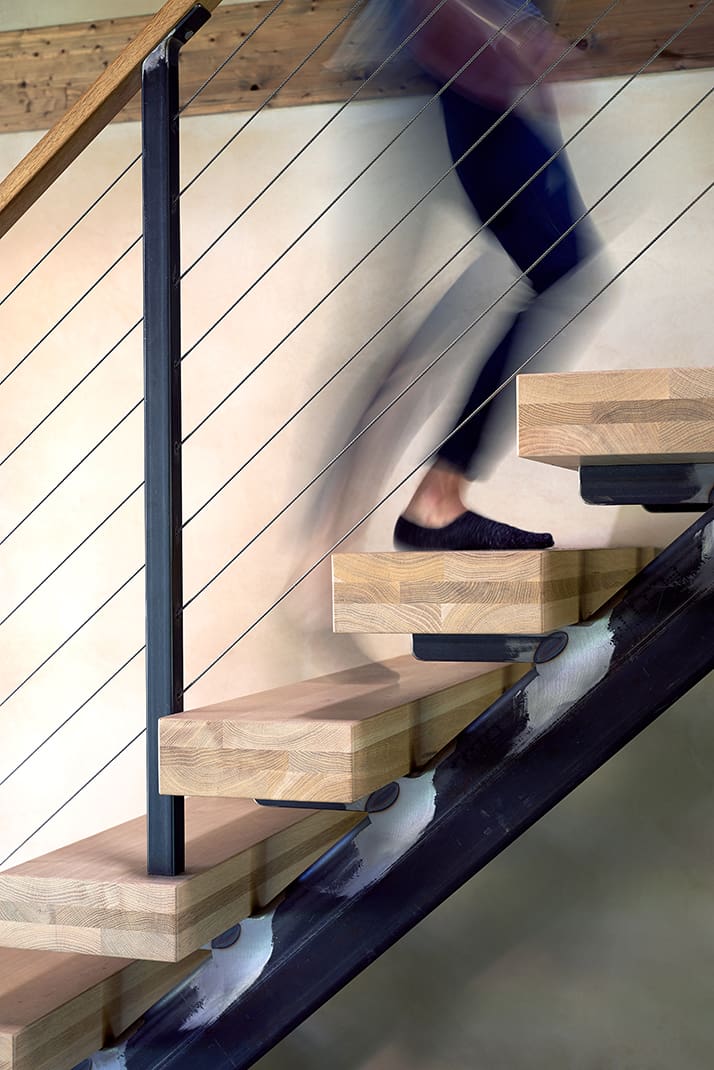 Close up of a woman ascending a wooden stair case