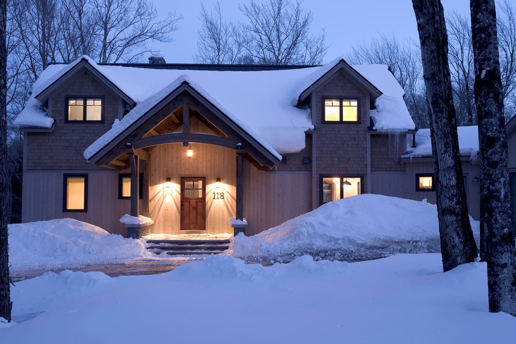 Exterior of an energy efficient home at dusk after a snow fall.