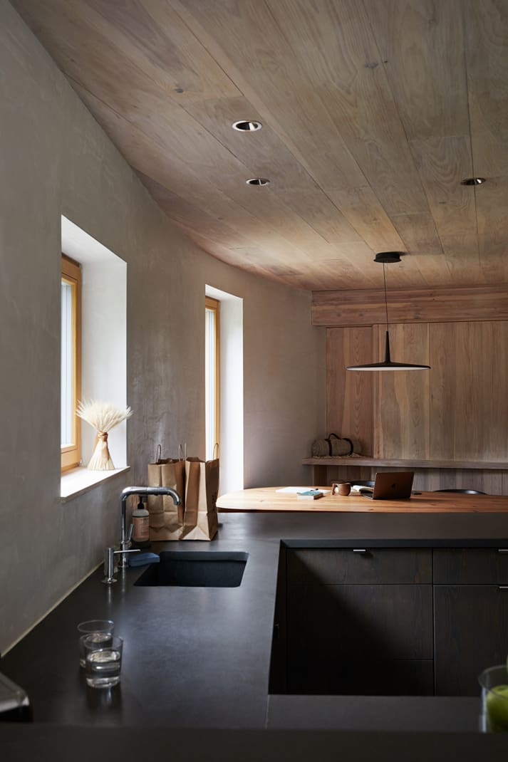 Kitchen with a rounded exterior wall and wood ceiling