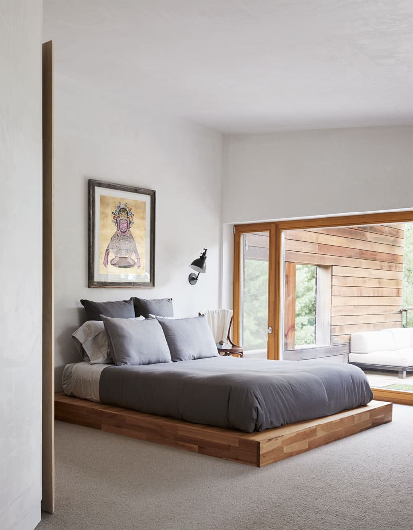 A low slung bed adorns the master bedroom with a view to the deck outside