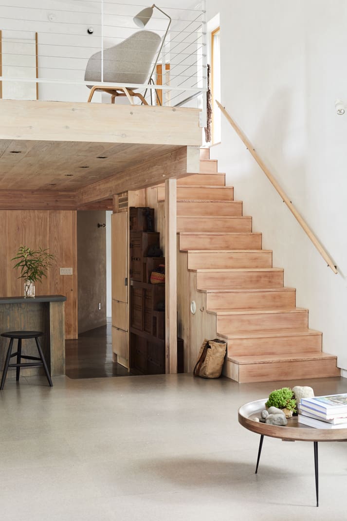 Stairs lead from the open kitchen area to an open loft