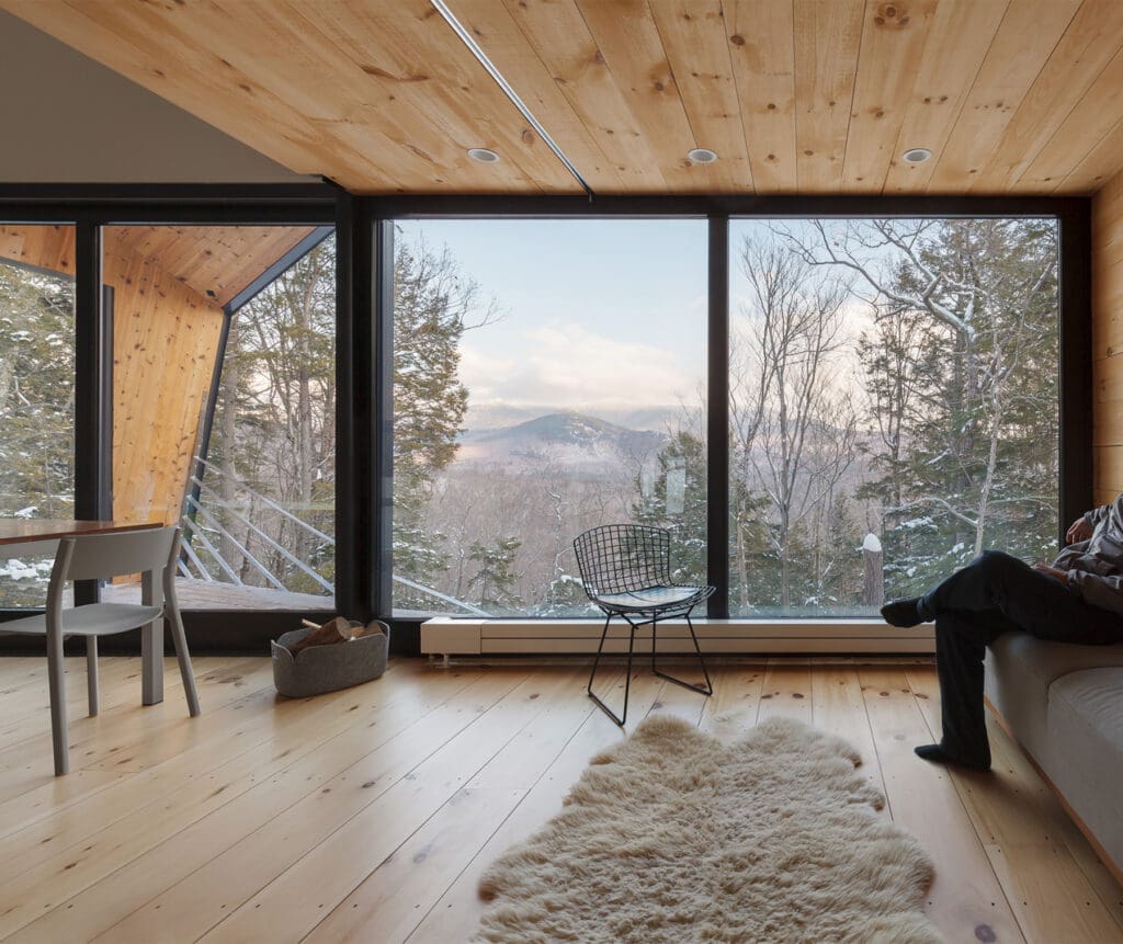Inside the living room looking out of the large bank of windows to the view below