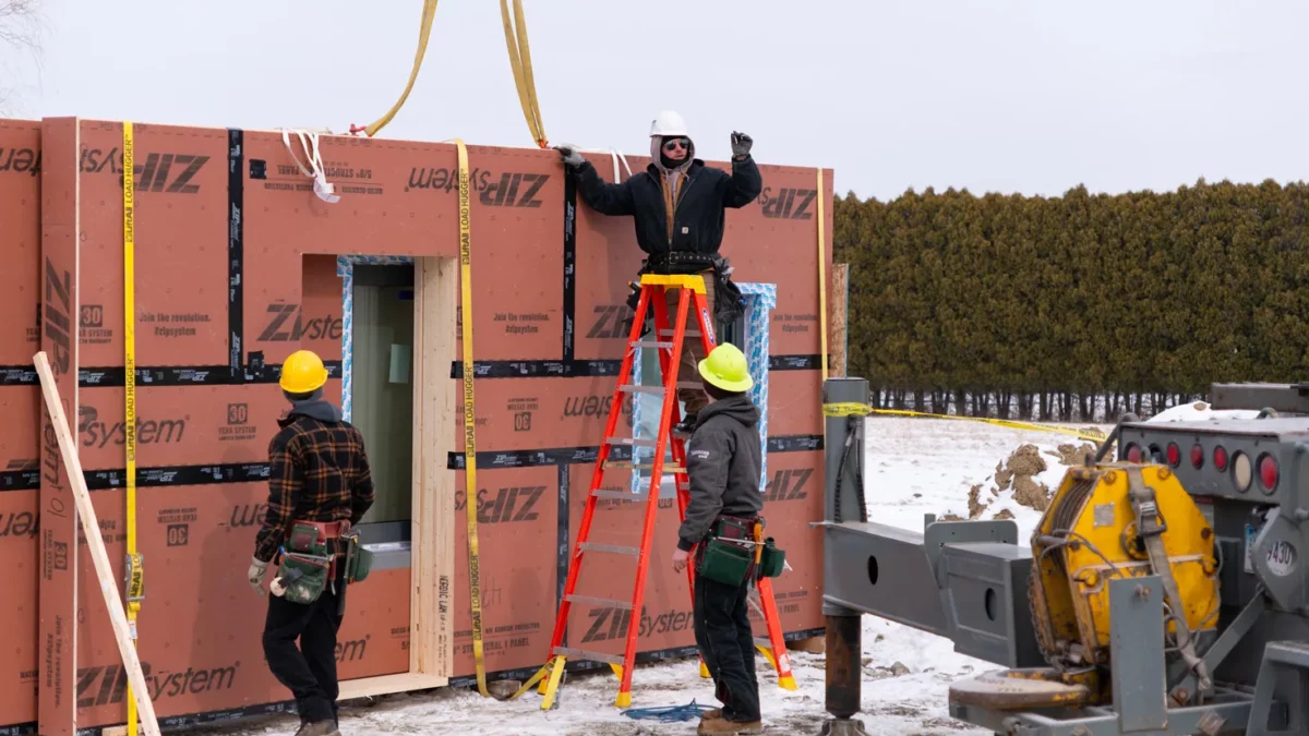 Bensonwood team on location securing a wall system to a crane.